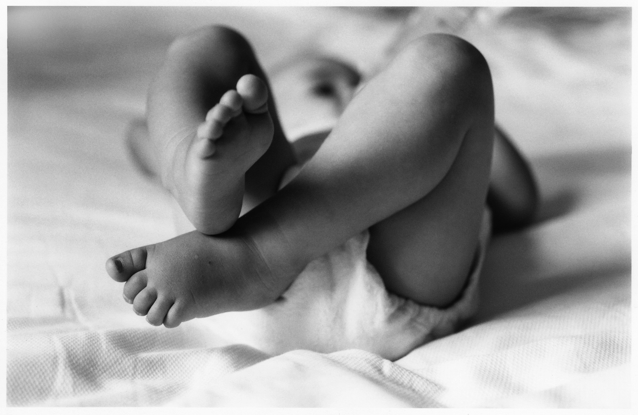 baby-legs-lying-on-blanket-bw