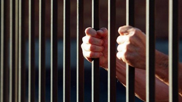 438940-prisoner-behind-bars