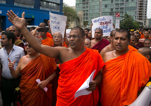 Monks from the Bodu Bala Sena (Buddhist power force) protest outside the Indian High Commission. (Bespectacled monk with his right arm outstretched is Galagoda Aththe Gnanasara, the general secretary of the Bodu Bala Sena.) The Sinhala-Buddhist organization gathered to protest a recent attack on the Buddagaya temple in India. Photo: Paula Bronstein for The Global Mail
